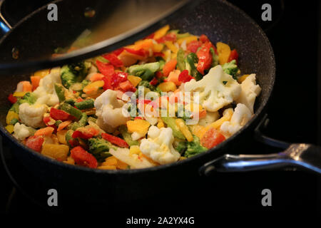 Le verdure surgelate, compreso pepe broccoli e cavolfiore essendo cotti Foto Stock