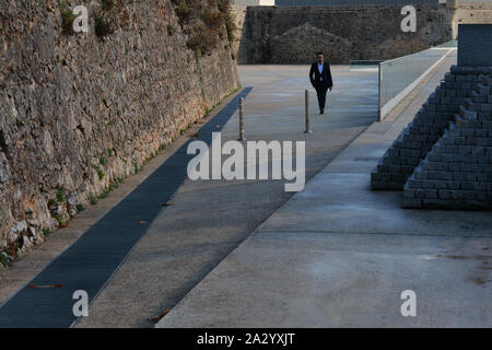 Street photography con uomo a piedi la cittadella di Cascais, Portogallo. Le piramidi di Cascais dal Bosc d'Anjou Foto Stock