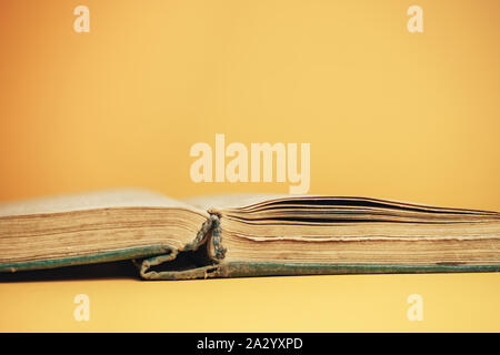 Close up bella aperta vecchio libro su sfondo giallo. Foto Stock