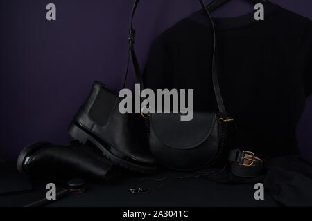Accessori di moda, chelsea stivali in pelle e t-shirt dress disposti in colore scuro ancora vita composizione Foto Stock