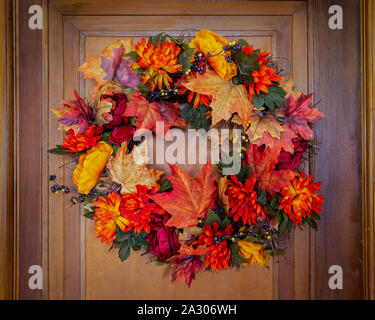 Un autunno ispirato ghirlanda appesa su una vecchia porta di legno. Foto Stock