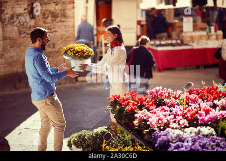 Uomo felice shopping per le piante al negozio di fiori sulla strada. Foto Stock