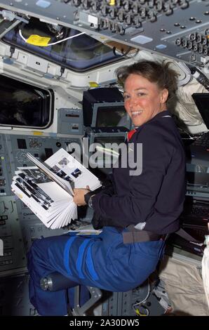 In orbita intorno alla Terra, STATI UNITI D'AMERICA. 7 Mar 2005. FILE: In questa foto rilasciata dalla NASA, Astronauta M. Lisa Nowak, STS-121 lo specialista di missione, utilizza un utile manuale di riferimento mentre stazionava presso i comandi del volo a poppa del ponte della navetta spaziale Discovery in orbita intorno alla Terra il 5 luglio 2006. Si sta preparando per la prossima giornata di attività che includono docking con la Stazione Spaziale Internazionale Credito: NASA/CNP/ZUMA filo/Alamy Live News Foto Stock