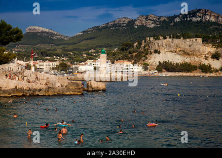 Menschen baden am Strand, Plage Le Bestouan, im Hintergrund der Leuchtturm von Cassis,Bouches-du-Rhone, Provence-Alpes-Côte d'Azur, Südfrankreich, Fra Foto Stock