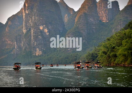 Il fiume Li turistica del parco barche a motore al di sotto di drammatici picchi di montagna, nel Guangxi, Cina Foto Stock