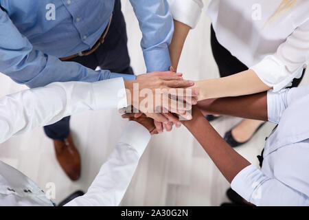 Vista superiore del giovane multirazziale Business persone mettere le loro mani insieme Foto Stock