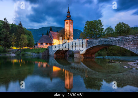 Chiesa di Sv. Giovanni Battista e un ponte dal lago di Bohinj nella notte, Slovenia. Chiesa di San Giovanni Battista con bridge. Il Parco Nazionale del Triglav, J Foto Stock