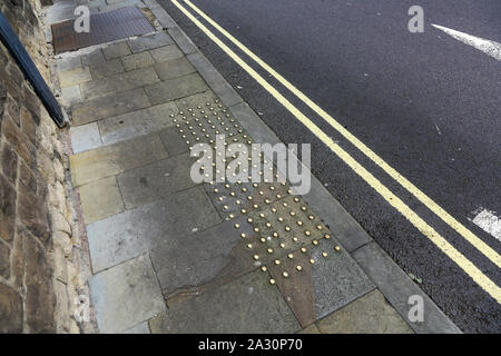 Prigionieri di ottone nella pavimentazione in corrispondenza di un attraversamento pedonale per aiutare i non vedenti, England, Regno Unito Foto Stock