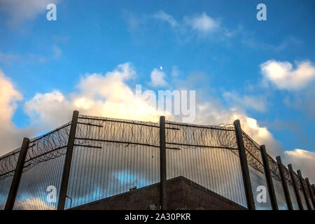 Le mura della prigione e un recinto con dei picchi sul cielo blu sullo sfondo. Peterhead Prison Museum, Aberdeenshire, Scotland, Regno Unito. Foto Stock