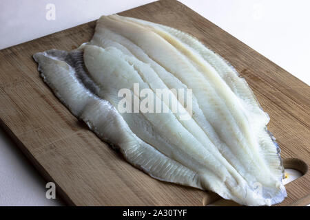 Fresche, materie non cotti passera di mare filetto di pesce sul tagliere Foto Stock