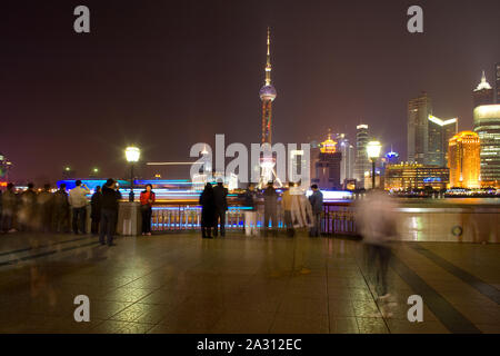 Shanhai, Cina - Persone a The Bund Riverside guardando lo skyline di Lujiazui Pudong e con la Oriental Pearl Tower Foto Stock