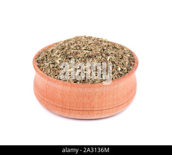 Origano essiccato in ciotola di legno per le spezie isolati su sfondo bianco. Origano tritato. Primo piano Foto Stock
