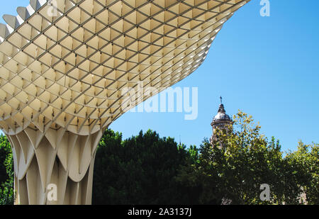 Parte di Las Setas (Metropol Parasol) con la Chiesa dell'Annunciazione (Iglesia de la Anunciación) in background in una giornata di sole Foto Stock