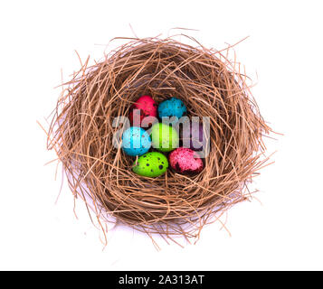 Uova di Pasqua nel nido verniciato, isolati su sfondo bianco. Colorate le uova di quaglia Foto Stock