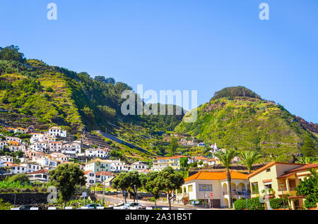 Villaggio pittoresco Porto Moniz nell'isola di Madeira, Portogallo. Bellissima costa settentrionale dell'isola. Piccola città portoghese circondata da verdi colline. Un paesaggio fantastico. Destinazione turistica. Foto Stock