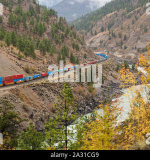 Il Canadian National treno merci che trasportano contenitori colorati a Vancouver attraverso il Thompson River Valley in British Columbia visto dal Rocky M Foto Stock