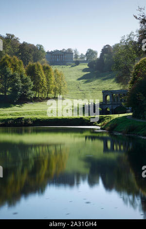 Prima parco giardino paesaggistico. Vista del ponte palladiano e la casa dal basso lago. Vasca da bagno. Regno Unito. Foto Stock