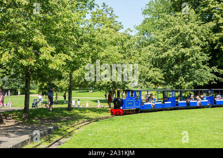 Persone e per vacanza in sella sulla miniatura convoglio ferroviario in Pavilion Gardens Buxton Derbyshire Inghilterra Foto Stock