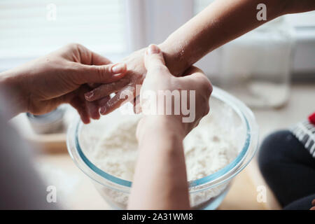 3-anno-vecchia ragazza la cottura del pane a casa, miscelando gli ingredienti secchi in un recipiente. Foto Stock