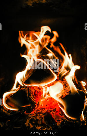 Un vicino l immagine del fuoco in un bruciatore di legno, qualcosa per portare il calore in casa Foto Stock