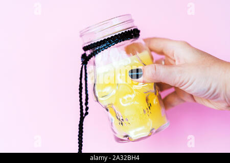 Creative giorno di Halloween composizione. Holiday candela vetro cranio in mano Foto Stock