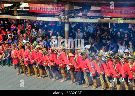 Il canto e la danza celebrazione del rosso e blu-derubato Tsou tribù al Tsou Mayasvi festival intorno alla Cuba, la tribù della riunione di casa del villaggio di Tefuye nel Alishan montagne. Cerimonia principale, tutti i membri della tribù, mano nella mano e portato dagli anziani, ballare e cantare canzoni in lode del Dio della guerra, e il canto le eroiche gesta dei loro antenati. vicino alla città di Chiayi, Taiwan, Asia Foto Stock