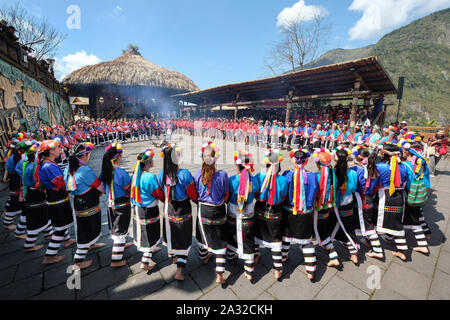 Il canto e la danza celebrazione del rosso e blu-derubato Tsou tribù al Tsou Mayasvi festival intorno alla Cuba, la tribù della riunione di casa del villaggio di Tefuye nel Alishan montagne. Cerimonia principale, tutti i membri della tribù, mano nella mano e portato dagli anziani, ballare e cantare canzoni in lode del Dio della guerra, e il canto le eroiche gesta dei loro antenati. vicino alla città di Chiayi, Taiwan, Asia Foto Stock