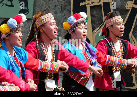 Il canto e la danza celebrazione del rosso e blu-derubato Tsou tribù al Tsou Mayasvi festival intorno alla Cuba, la tribù della riunione di casa del villaggio di Tefuye nel Alishan montagne. Cerimonia principale, tutti i membri della tribù, mano nella mano e portato dagli anziani, ballare e cantare canzoni in lode del Dio della guerra, e il canto le eroiche gesta dei loro antenati. vicino alla città di Chiayi, Taiwan, Asia Foto Stock