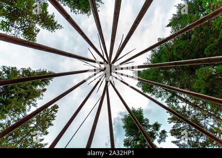 Un worm'occhio di un teepee alti (tende Tepee) struttura, costruito tra alberi di alto fusto in corrispondenza di un luogo sacro dedicato a sciamano e culto nativo. Foto Stock