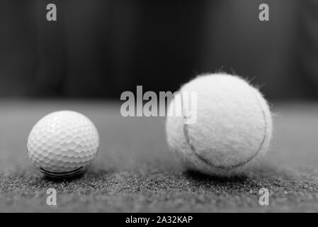 La pallina da golf e palla da tennis su terra girato in bianco e nero Foto Stock