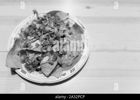 Deliziosa scorpacciata di nachos con formaggio e Guacamole sul tavolo di legno Foto Stock