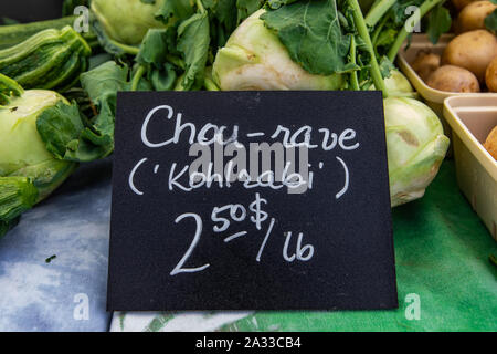 Un Francese prezzo canadese segno è visto closeup, pubblicità freschi Cavoli ricci (tedesco rapa) venduti a peso su un mercato in stallo durante un cibo biologico fiera. Foto Stock