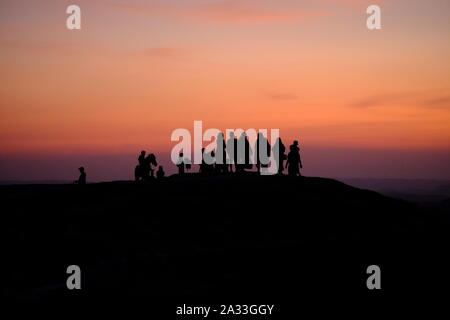 Indonesia Isola di Sumba Bukit Wairinding silhouette di gente a guardare il tramonto Foto Stock