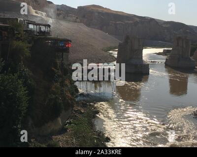 09 settembre 2019, Turchia, Hasankeyf: Vista di scogliere e caffè sopra il fiume Tigri durante il tramonto. Il villaggio si trova in un unico paesaggio culturale sul Tigri. La gente è stata supposta per stabilirsi qui per circa 12.000 anni. Ma ben presto Hasankeyf affonderà sotto il livello di acqua di un enorme serbatoio. Circa 70 chilometri più a valle il nuovo Megadam Ilisu ha iniziato i lavori ed è stata damming acqua per diverse settimane. Secondo le autorità locali, il cuore del piccolo centro città è di essere evacuata ed in parte demolito dal 8 ottobre. Le persone hanno per passare a una nuova città, che essi h Foto Stock