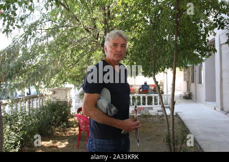 09 settembre 2019, Turchia, Hasankeyf: il tedesco ambientalista e attivista Ulrich Eichelmann sorge accanto a un "albero della speranza che egli ha piantato anni fa in Hasankeyf nella Turchia sudorientale. Fino al 2010, Eichelmann ha organizzato una grande parte della resistenza contro il progetto della diga di Ilisu in prossimità di Hasankeyf per anni. Il villaggio si trova in un unico paesaggio culturale sul Tigri. La gente è stata supposta per stabilirsi qui per circa 12.000 anni. La diga, tuttavia, ora è finito ed è stato damming acqua per diverse settimane. Verso la fine dell'anno Hasankeyf avrà affondato nel serbatoio. Quindi, il quadro strumenti elettronico ( EIC ) Foto Stock