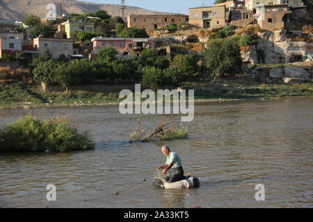 Hasankeyf, Turchia. 09Sep, 2019. Un pescatore getta le reti in modo tradizionale in fiume Tigri. L'insediamento, che è di circa 12.000 anni, è sprofondare sotto il livello di acqua di un enorme serbatoio entro la fine dell'anno. Secondo le autorità locali, il cuore del piccolo centro città è di essere evacuata ed in parte demolito dal 8 ottobre. La gente deve passare per il centro di Neustadt, che avevano boicottato per un lungo periodo di tempo. Sono in molti a temere non solo la perdita delle loro case, ma anche la perdita delle loro tradizioni. Credito: Christine-Felice Röhrs/dpa/Alamy Live News Foto Stock