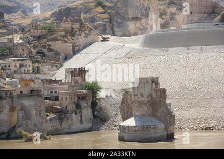 09 settembre 2019, Turchia, Hasankeyf: lavori di costruzione al di sotto dell'antico castello di Hasankeyf sul fiume Tigri nel sud-est della Turchia. Un massiccio bastione è creato per proteggere la scogliera soft rock contro le inondazioni. Si desidera interrompere il castello di scivolare nel lago. Entro la fine dell'anno al più tardi, Hasankeyf, che si dice sia stata abitata per circa 12.000 anni, sarà sotto l'acqua. Circa 70 chilometri più a valle il nuovo Megadam Ilisu ha iniziato i lavori ed è stata damming acqua per diverse settimane. Secondo le autorità locali, il cuore del piccolo centro città è t Foto Stock