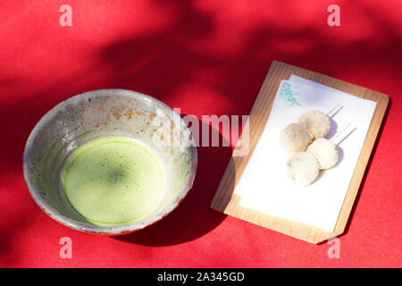 Giapponese di tè verde Matcha in un vaso di ceramica con wagashi Foto Stock