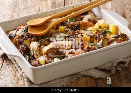 In casa tradizionale casseruola di pollo con funghi porcini e patate e rosmarino close-up in una teglia sul tavolo orizzontale. Foto Stock