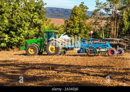 Il trattore sul campo. La coltivazione per allentare il suolo. Il trattore coltiva campo. In autunno il lavoro su farmin agricoli nella Repubblica ceca - Europa. Foto Stock