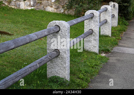 Recinzione di colonne di pietra e barre di legno Foto Stock