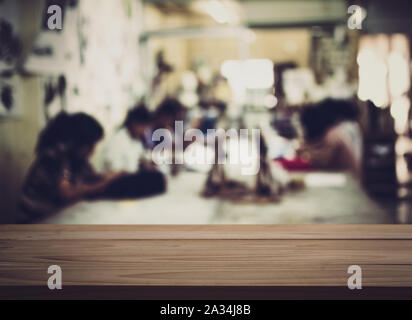 Svuotare tavolo in legno con bambini sfocata in sala d'arte sfondo. Per la visualizzazione del prodotto. Foto Stock