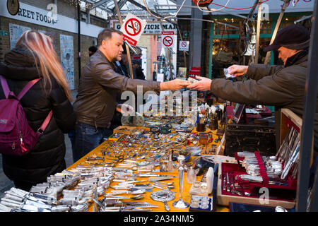 Il cliente / acquirente paga e tenendo articolo acquistato / scambio di pagamento per il cambio dei soldi da stallholder al collezionismo e mercatino di antiquariato, Gree mercato di Greenwich, Londra. Regno Unito (105) Foto Stock