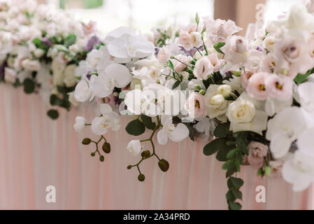 Una lunga composizione di freschi Fiori di lusso sulla tabella di nozze dello sposo e della sposa. Decorazione di nozze con fiori in toni murata Foto Stock