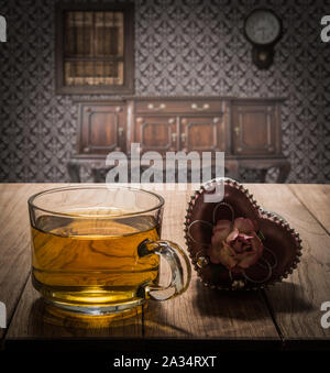 Tea time con cuore dono sul tavolo di legno in interni vintage Foto Stock