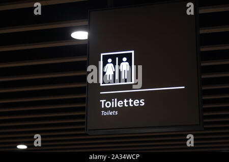 Etichetta del simbolo di servizi igienici per gli uomini e le donne sulla piastra blu, segno di direzione e il puntatore di navigazione wc toilette nell'edificio, aeroporto, stazione Foto Stock