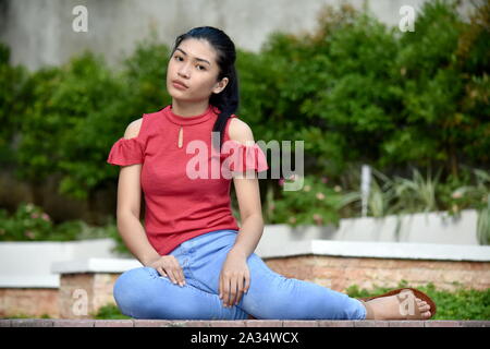 Una seduta giovane ragazza asiatica Foto Stock