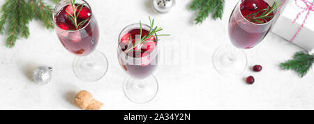Natale mirtillo rosso mimosa con rosmarino su sfondo bianco, copia spazio banner. Cocktail con champagne per la mattina di Natale. Foto Stock