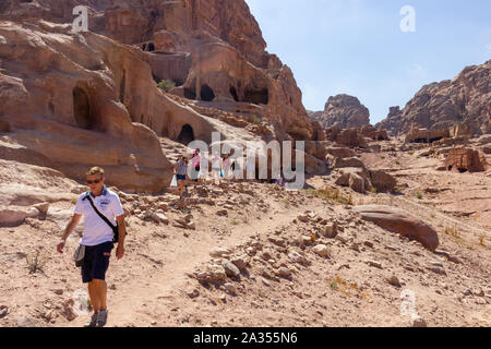 Petra, Giordania - Settembre 21, 2013: Attività Sportive giovani turisti a piedi lungo la vecchia tomba case che sono scolpite nelle montagne di Petra, Giordania Foto Stock