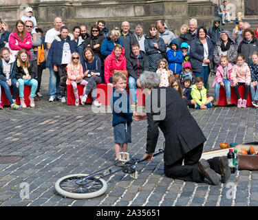 Ragazzo dal pubblico godendo di prendere parte in atto di strada. Edinburgh Fringe Festival Foto Stock